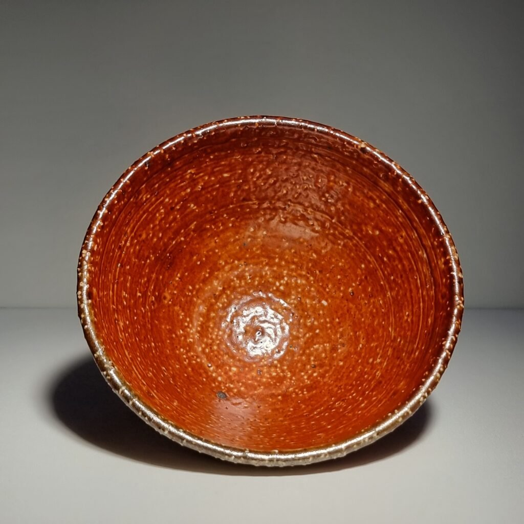 Handmade rustic speckled matcha bowl in warm rust tones